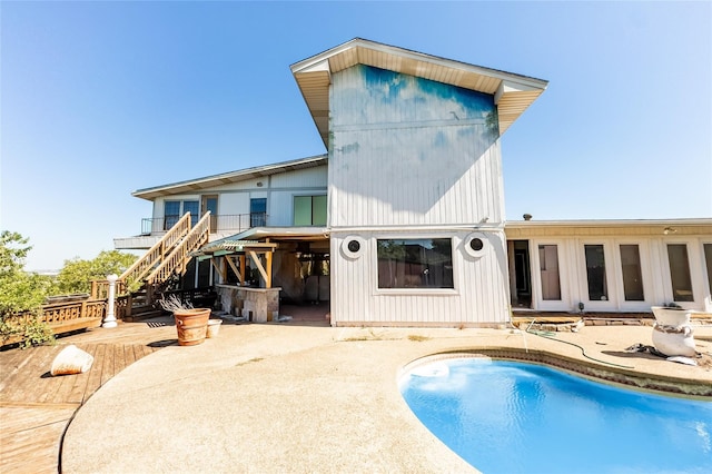 rear view of property with a pool side deck and a patio