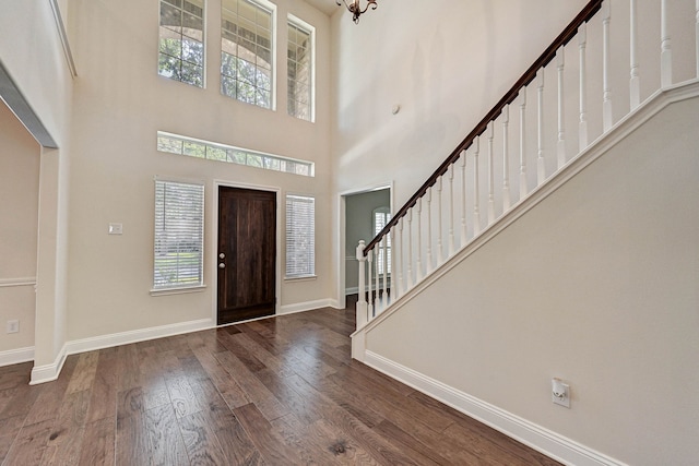 entryway with dark wood-type flooring and a high ceiling