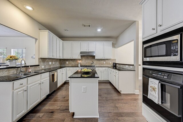 kitchen featuring sink, a kitchen island, appliances with stainless steel finishes, and white cabinetry