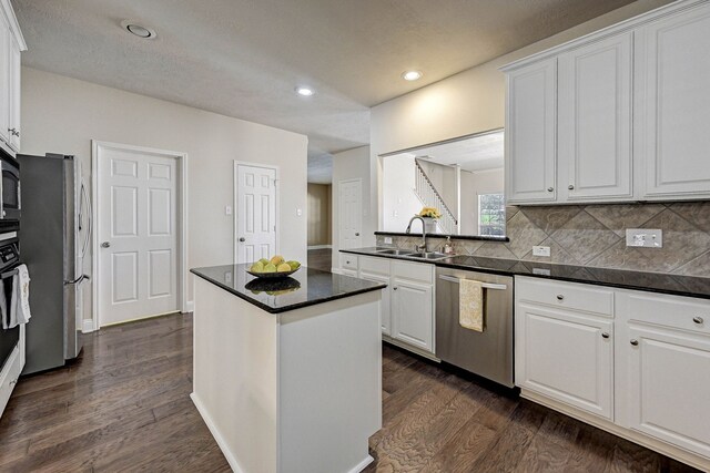 kitchen with white cabinetry, stainless steel appliances, sink, and dark hardwood / wood-style floors