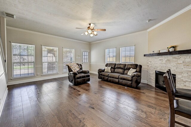 living room with ornamental molding, a textured ceiling, a healthy amount of sunlight, and dark hardwood / wood-style flooring