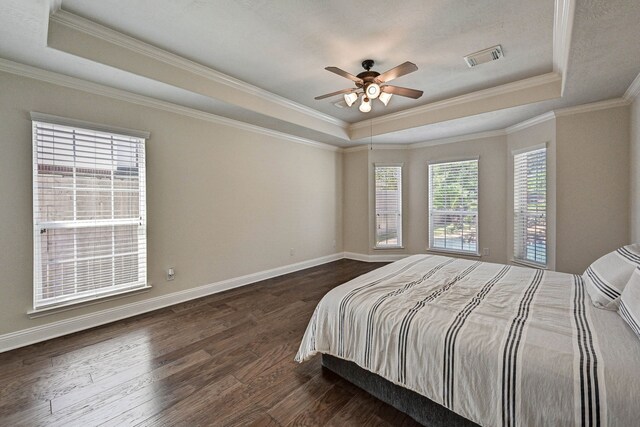 bedroom with ornamental molding, dark hardwood / wood-style floors, a raised ceiling, and ceiling fan