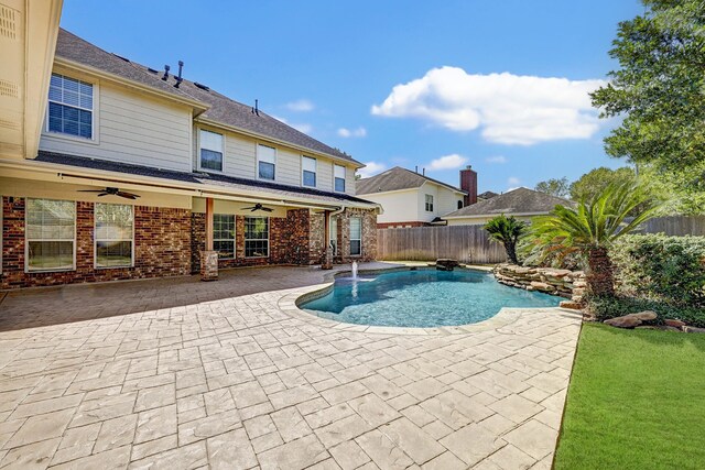 view of pool featuring pool water feature, a patio area, and ceiling fan