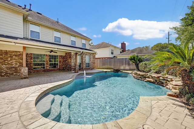 view of pool with a patio, ceiling fan, and pool water feature