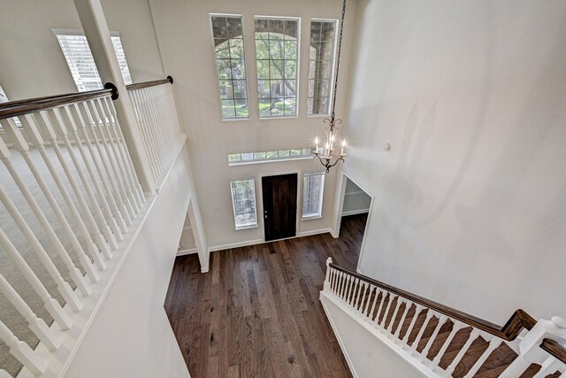 foyer entrance featuring dark wood-type flooring and a notable chandelier