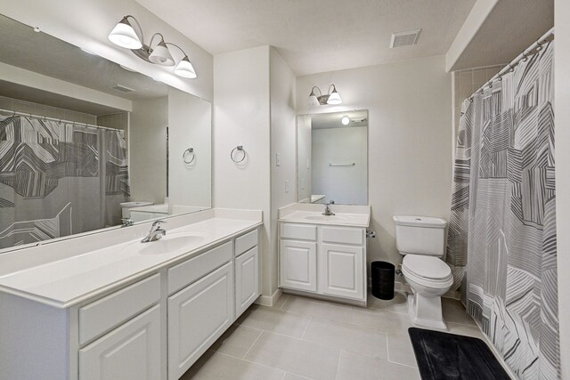 bathroom featuring vanity, walk in shower, toilet, and tile patterned floors