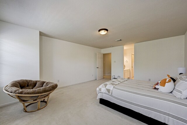 carpeted bedroom featuring ensuite bathroom