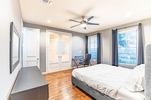 bedroom featuring ceiling fan, light wood-type flooring, and french doors