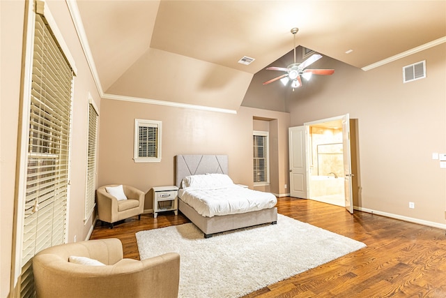 bedroom featuring ceiling fan, crown molding, ensuite bathroom, wood-type flooring, and vaulted ceiling