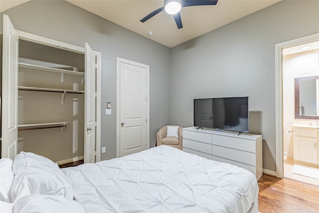 bedroom featuring light hardwood / wood-style floors, ensuite bath, and ceiling fan