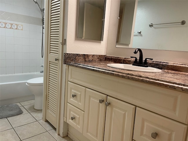 full bathroom featuring tiled shower / bath, tile patterned floors, vanity, and toilet