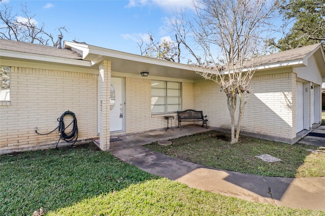 property entrance with a yard and a garage