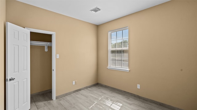 unfurnished bedroom featuring light hardwood / wood-style flooring and a closet