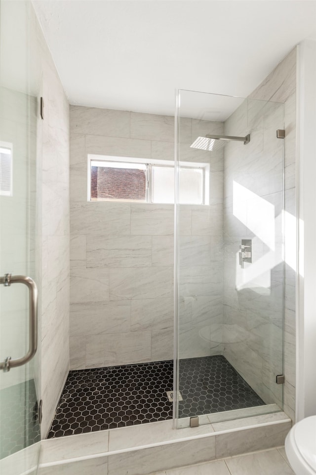 bathroom with tile patterned flooring, toilet, and walk in shower