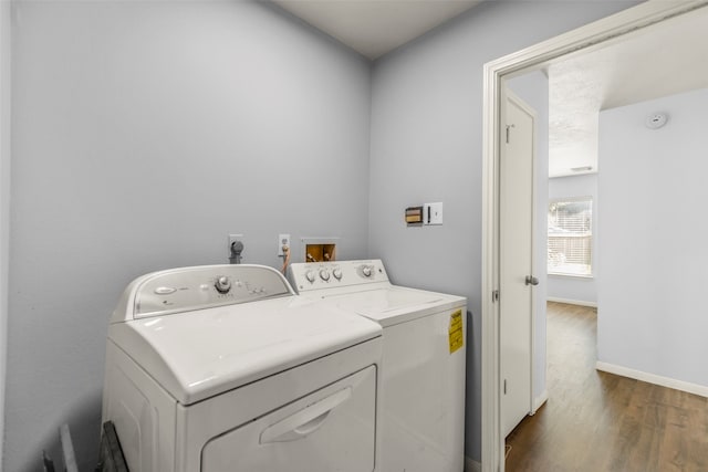 laundry area with washing machine and dryer and dark wood-type flooring