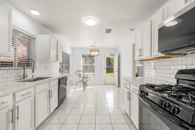 kitchen featuring light tile patterned flooring, sink, black appliances, pendant lighting, and white cabinets