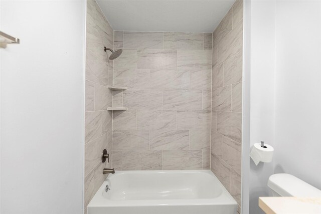 bathroom with toilet and tiled shower / bath combo