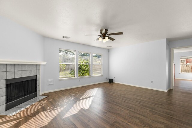 unfurnished living room with a fireplace, dark hardwood / wood-style flooring, and ceiling fan