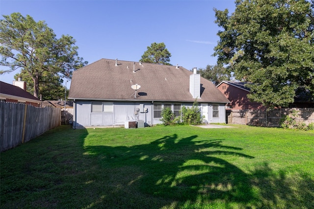 rear view of house with a yard and central AC unit