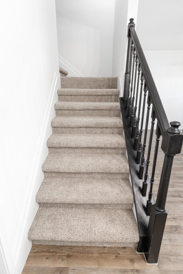 stairs featuring hardwood / wood-style floors