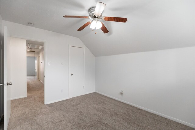 additional living space with light carpet, vaulted ceiling, and ceiling fan