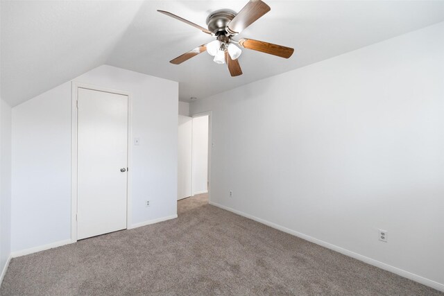 unfurnished bedroom featuring ceiling fan, light colored carpet, and lofted ceiling