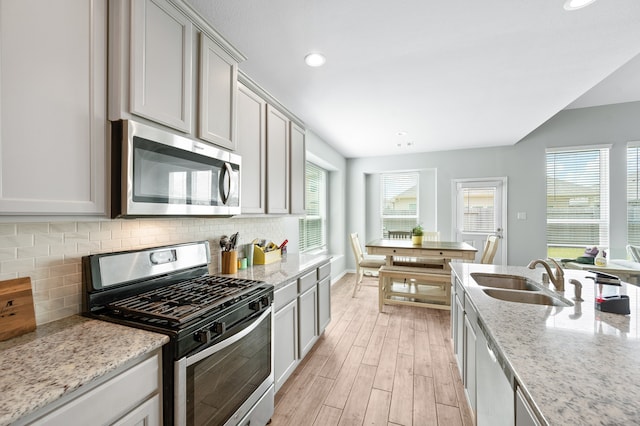 kitchen with light hardwood / wood-style flooring, appliances with stainless steel finishes, sink, and a wealth of natural light