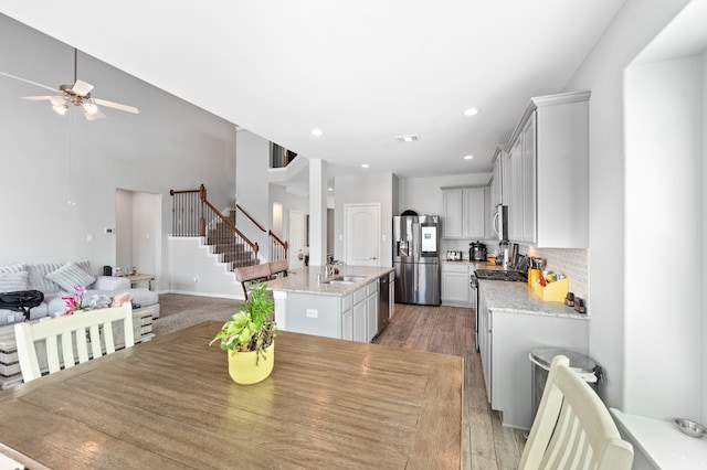 dining space with ceiling fan, sink, and light hardwood / wood-style floors