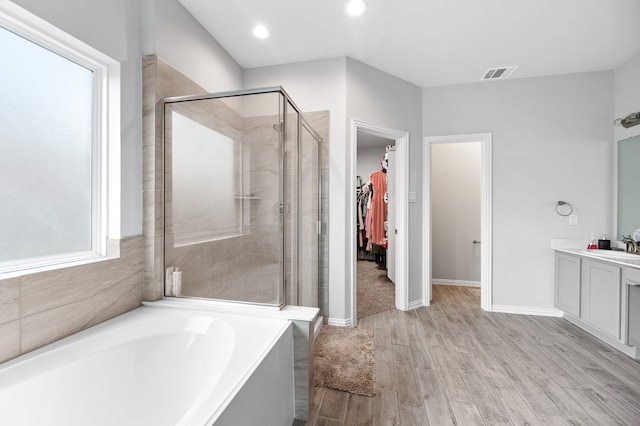 bathroom featuring hardwood / wood-style flooring, separate shower and tub, and vanity