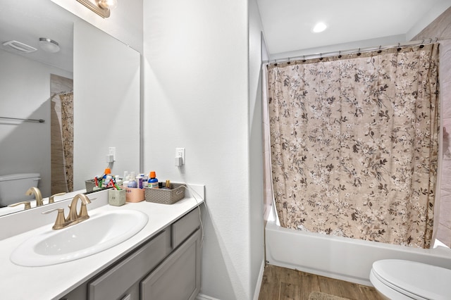 full bathroom with wood-type flooring, vanity, shower / bath combo with shower curtain, and toilet