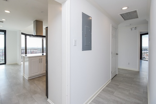 hall with plenty of natural light, electric panel, and crown molding