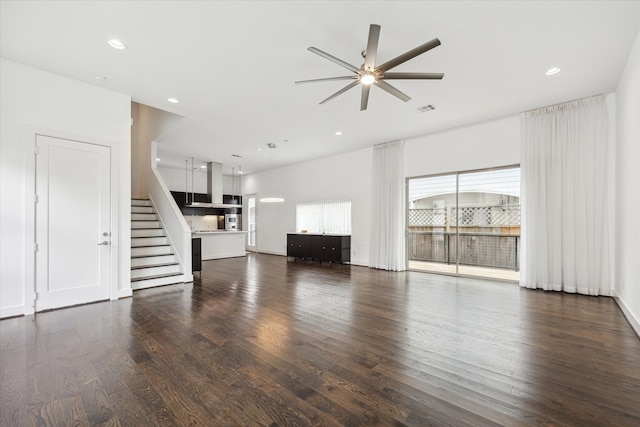 unfurnished living room with ceiling fan and dark hardwood / wood-style flooring