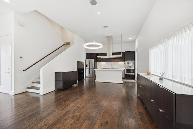 kitchen with a kitchen island, hanging light fixtures, ventilation hood, appliances with stainless steel finishes, and dark hardwood / wood-style flooring