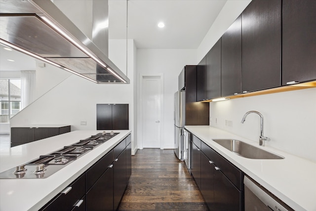 kitchen with dark wood-type flooring, wall chimney exhaust hood, appliances with stainless steel finishes, and sink