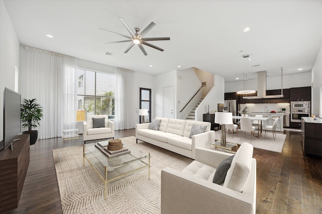 living room featuring ceiling fan, sink, and dark hardwood / wood-style floors