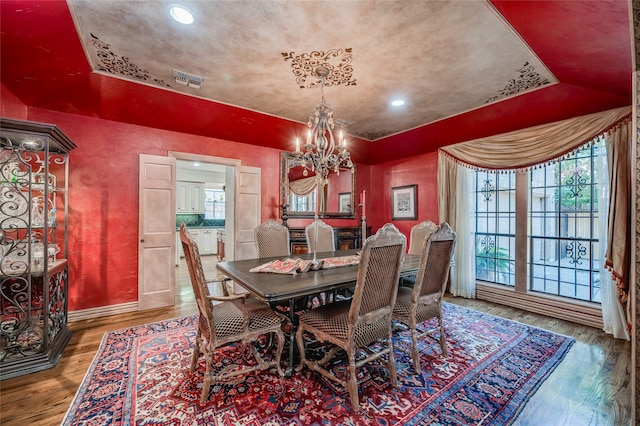 dining space featuring hardwood / wood-style floors and a notable chandelier