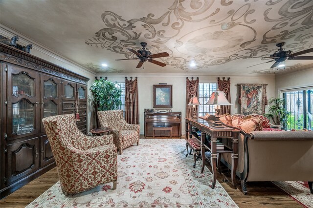 living area featuring ornamental molding, a ceiling fan, and light wood finished floors