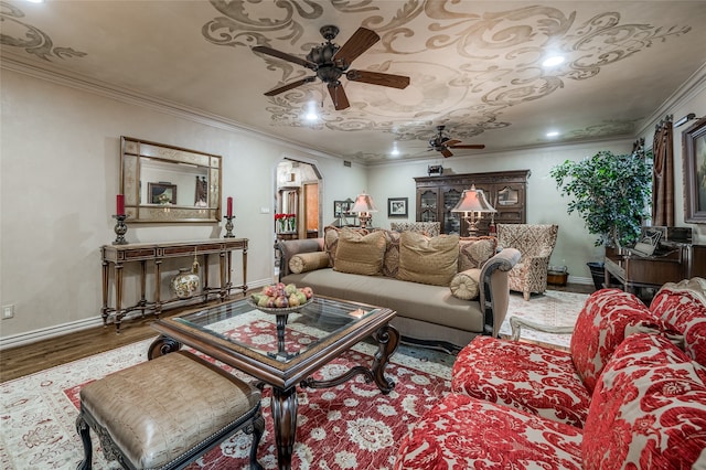 living room featuring wood-type flooring, crown molding, and ceiling fan