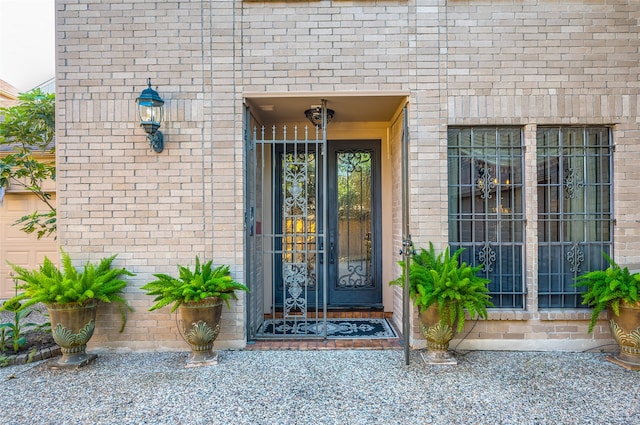 view of exterior entry featuring brick siding