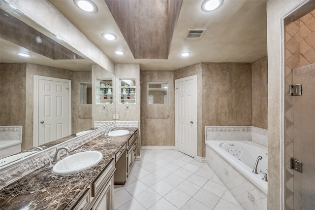 bathroom featuring tile patterned flooring, tiled tub, and vanity