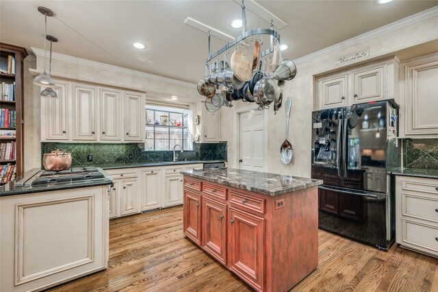 kitchen featuring backsplash, crown molding, light wood finished floors, and freestanding refrigerator