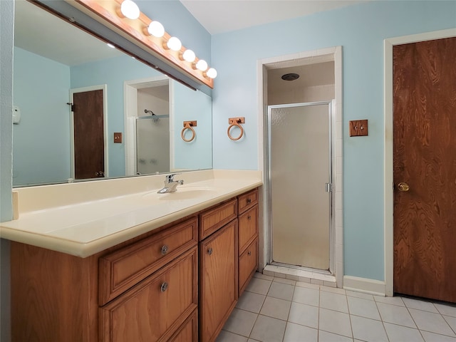 bathroom with tile patterned flooring, vanity, and a shower with shower door