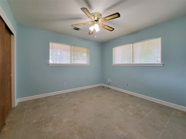 tiled spare room with ceiling fan and a healthy amount of sunlight