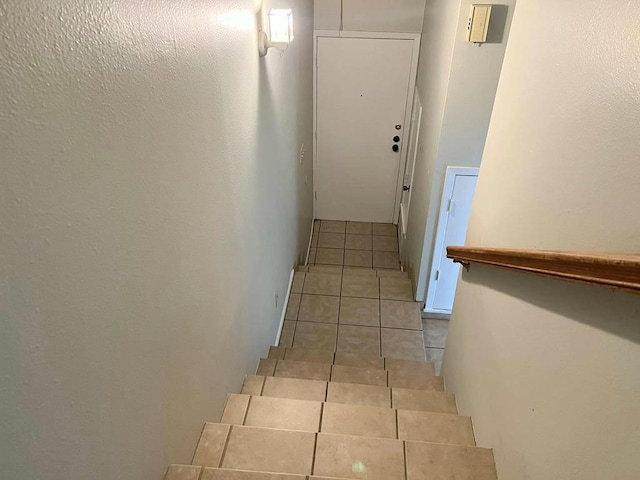 stairway featuring tile patterned flooring