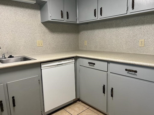 kitchen featuring dishwasher, backsplash, sink, light tile patterned flooring, and gray cabinets