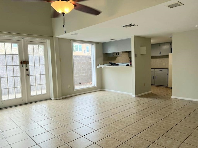 empty room with french doors, ceiling fan, and light tile patterned floors