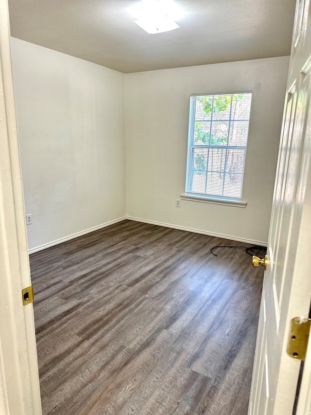 empty room with dark hardwood / wood-style flooring