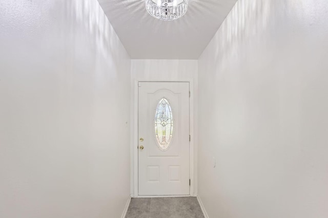 doorway to outside with light colored carpet