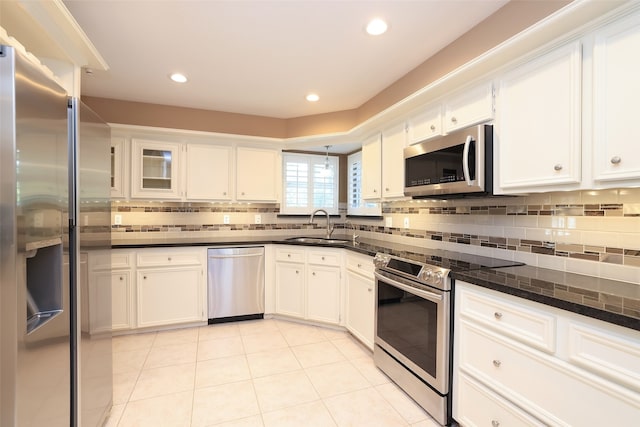 kitchen with light tile patterned floors, stainless steel appliances, white cabinetry, and sink