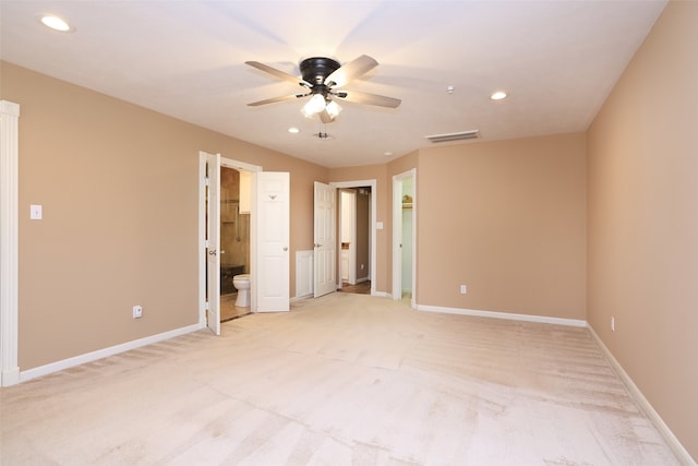 unfurnished bedroom featuring ensuite bath, ceiling fan, and light carpet